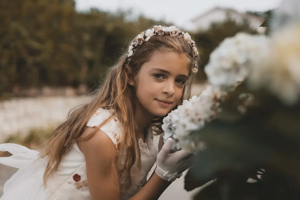 Portrait of a girl in a flower crown holding a white blossom