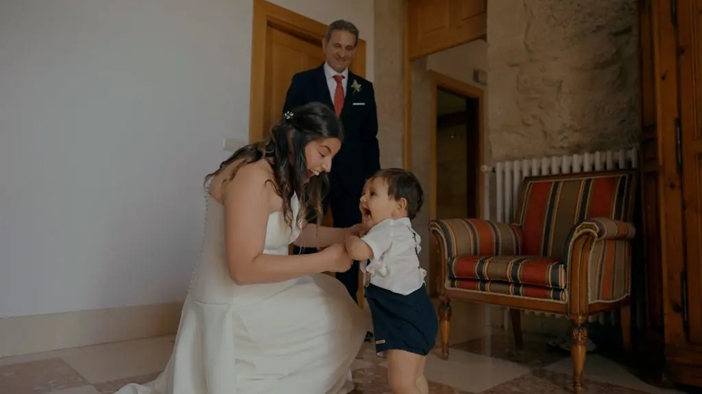 The bride crouches to embrace a small child before the ceremony