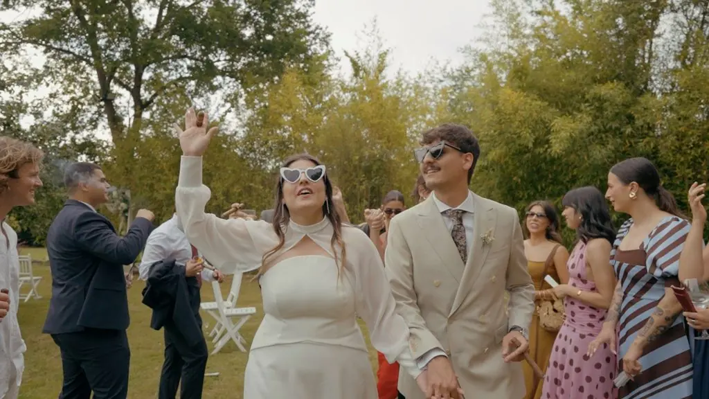 The couple, in sunglasses, celebrate among their guests